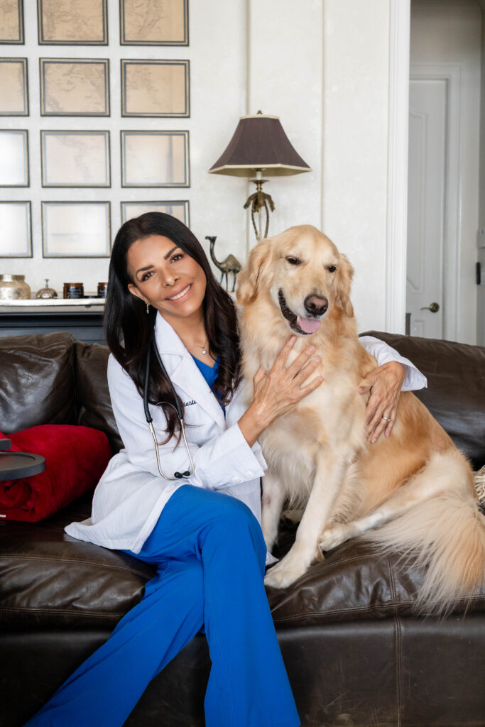 Veterinarian with golden retriever on leather sofa in upscale office setting